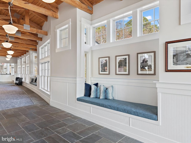 corridor with beamed ceiling, high vaulted ceiling, and wooden ceiling