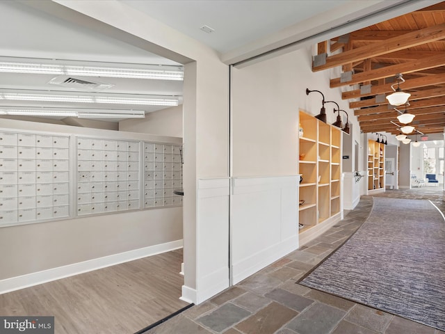 corridor featuring a mail area, beam ceiling, and dark wood-type flooring