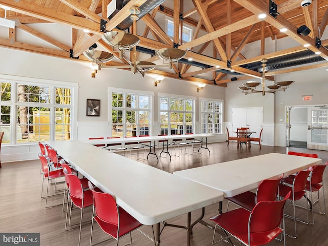 kitchen with beamed ceiling, high vaulted ceiling, hardwood / wood-style floors, a kitchen bar, and wood ceiling