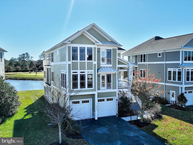 view of front of home featuring a front yard, a water view, covered porch, and a garage