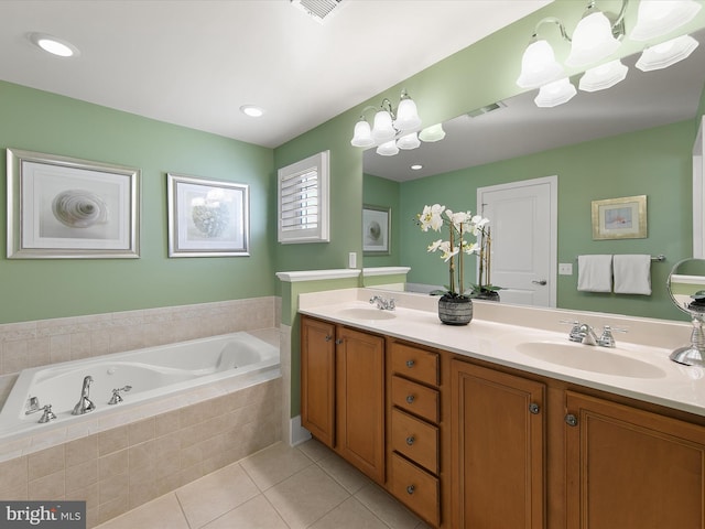 bathroom with tiled tub, tile patterned flooring, and vanity