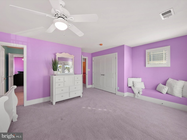 carpeted bedroom featuring a closet, ceiling fan, and multiple windows