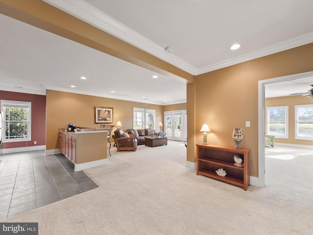 carpeted living room with a wealth of natural light, ceiling fan, and crown molding