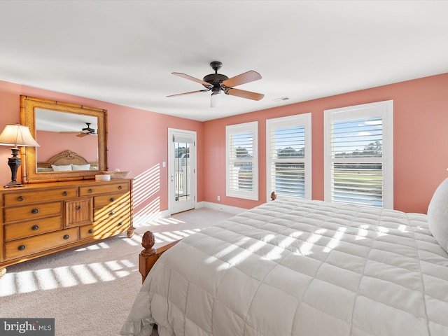 bedroom featuring access to outside, light colored carpet, multiple windows, and ceiling fan