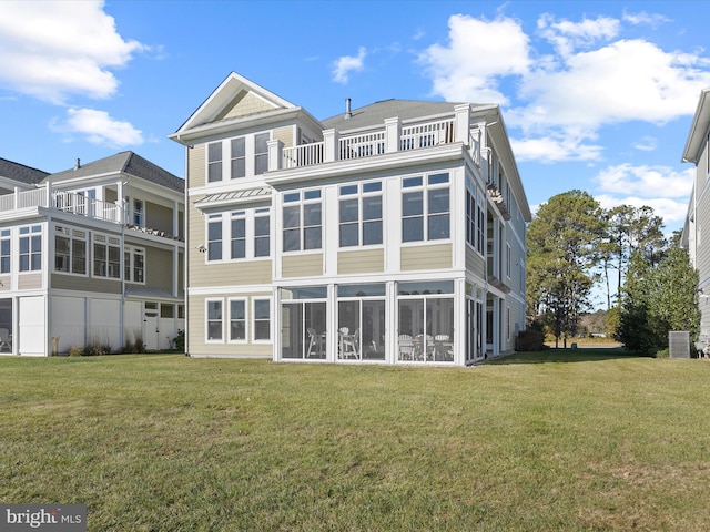 back of property with a yard and a balcony