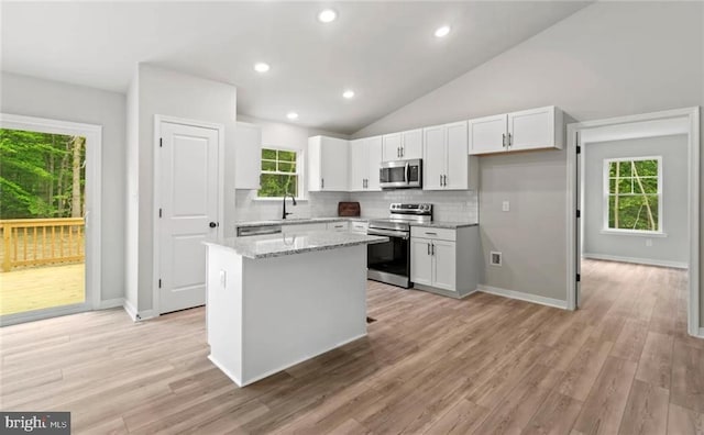 kitchen featuring white cabinetry, appliances with stainless steel finishes, and plenty of natural light