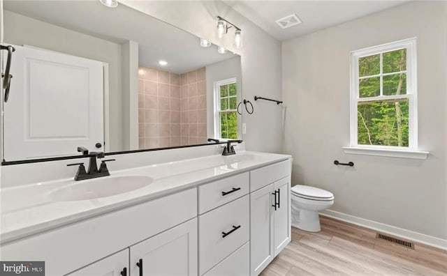 bathroom with wood-type flooring, toilet, and vanity