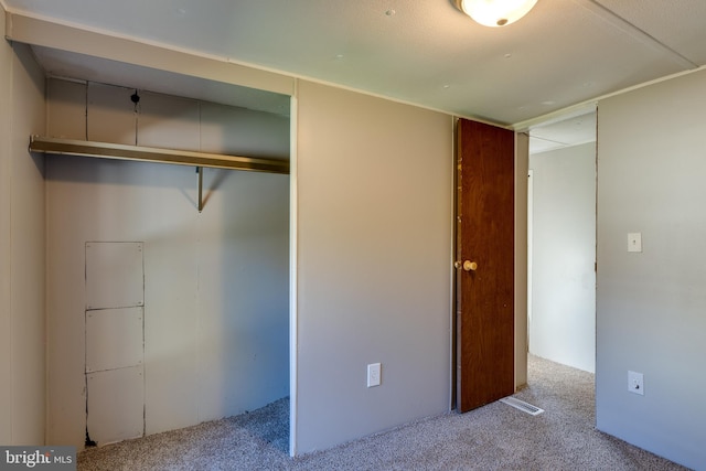 unfurnished bedroom featuring a closet and light colored carpet