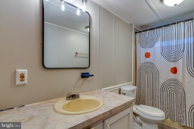 bathroom with curtained shower, vanity, and toilet