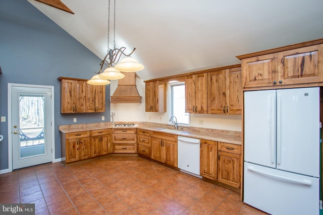 kitchen featuring lofted ceiling, a healthy amount of sunlight, hanging light fixtures, custom exhaust hood, and white appliances