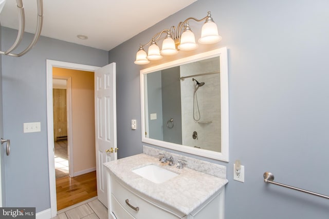 bathroom featuring vanity, hardwood / wood-style flooring, and tiled shower