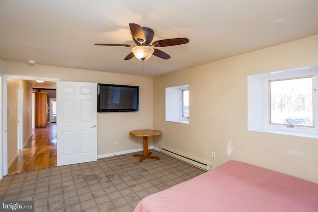 unfurnished bedroom featuring baseboard heating, hardwood / wood-style floors, multiple windows, and ceiling fan