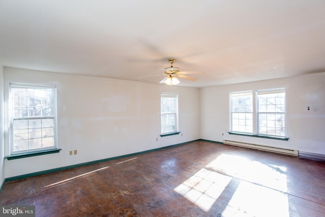 empty room with ceiling fan, baseboard heating, and dark wood-type flooring