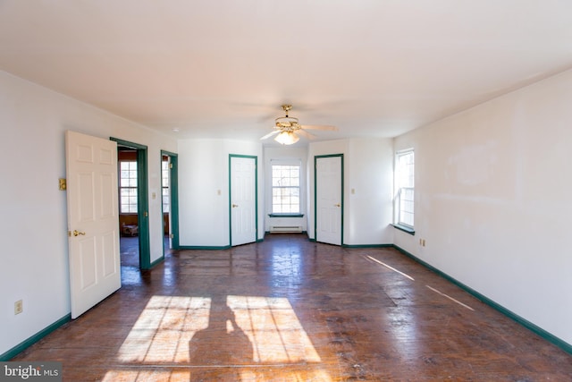 spare room with a wealth of natural light, ceiling fan, and dark hardwood / wood-style flooring