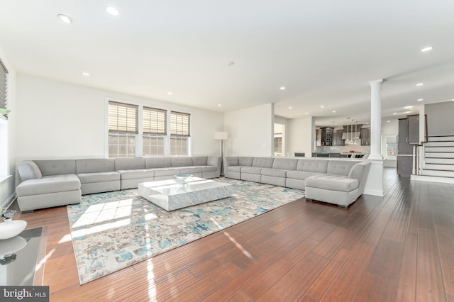 living room featuring ornate columns and wood-type flooring