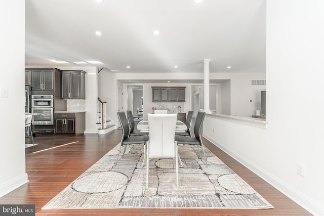 dining area featuring dark hardwood / wood-style floors and ornate columns