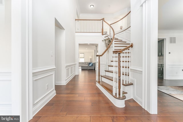 entryway with hardwood / wood-style floors and ornamental molding