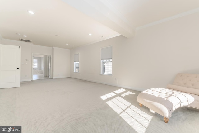 sitting room with beamed ceiling, light colored carpet, and crown molding