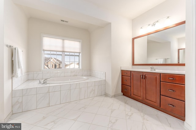 bathroom with tiled bath and vanity