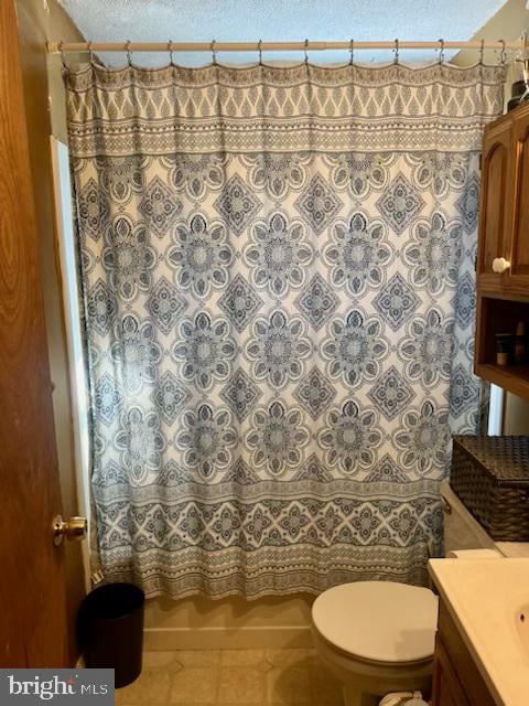 full bathroom featuring tile patterned floors, vanity, toilet, and shower / tub combo with curtain