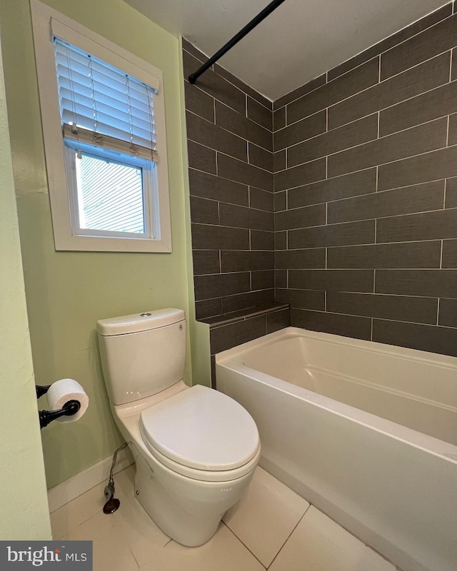 bathroom with toilet, tiled shower / bath combo, and tile patterned floors