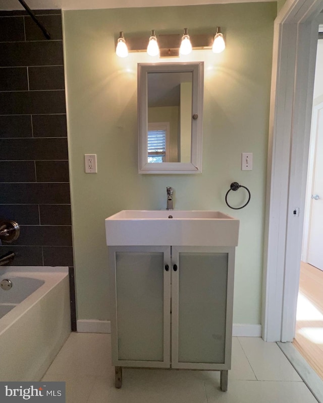 bathroom with washtub / shower combination, tile patterned floors, and vanity