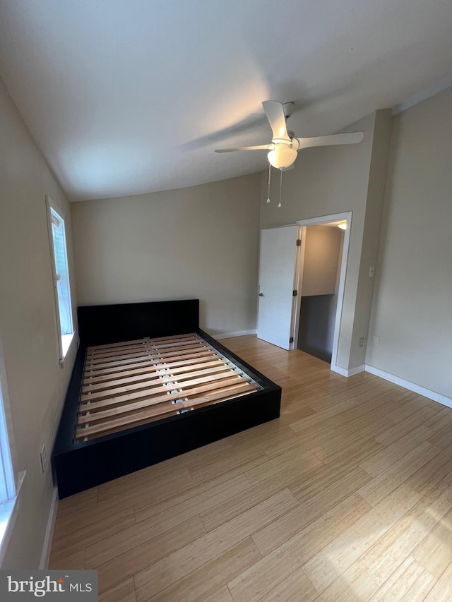 unfurnished bedroom with vaulted ceiling, ceiling fan, and light hardwood / wood-style flooring