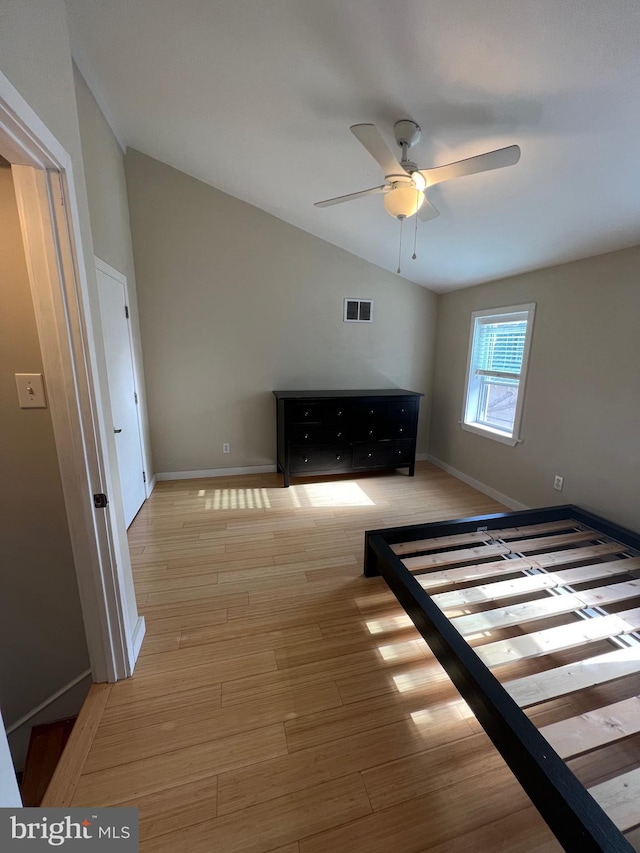 unfurnished bedroom with ceiling fan, light wood-type flooring, and lofted ceiling