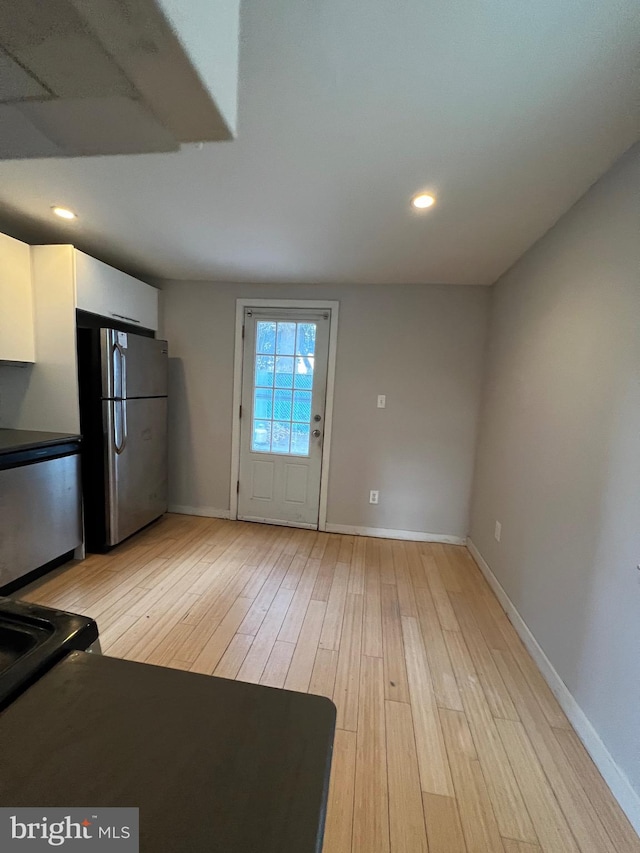 kitchen featuring white cabinetry, light wood-type flooring, and stainless steel refrigerator