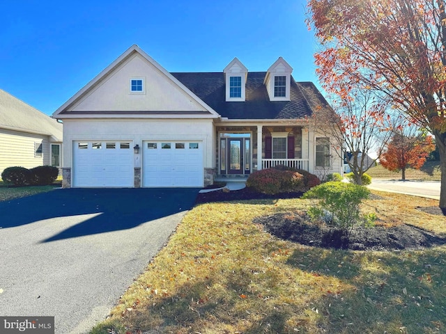 cape cod house featuring a front lawn, a garage, and covered porch