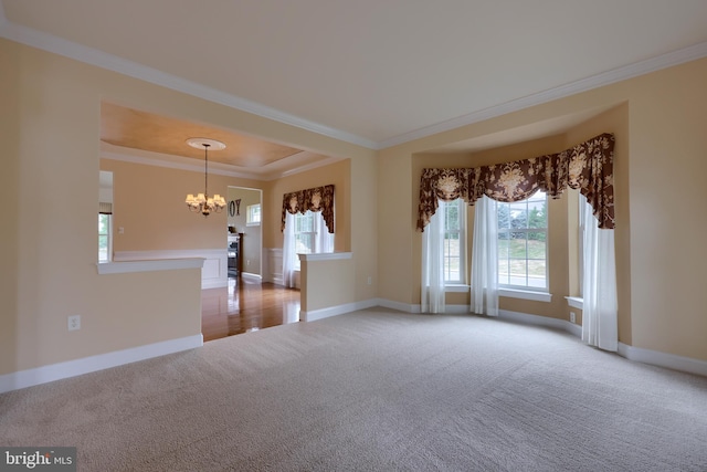 carpeted empty room featuring an inviting chandelier and ornamental molding