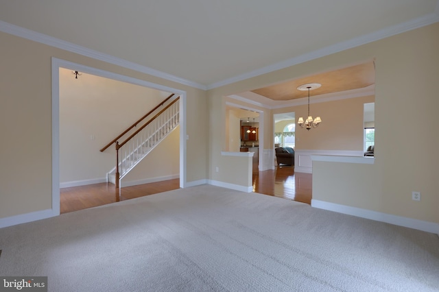 spare room featuring wood-type flooring, an inviting chandelier, and crown molding