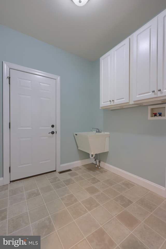 laundry area with cabinets, hookup for a washing machine, light tile patterned floors, and sink