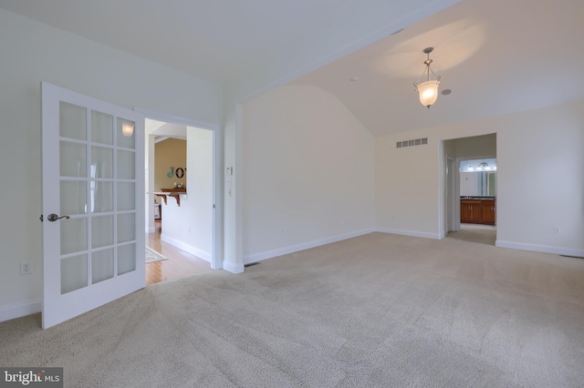 unfurnished room with light carpet and lofted ceiling