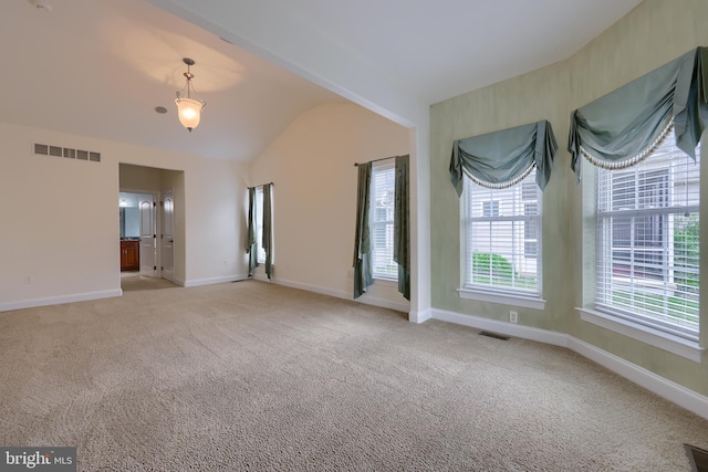 carpeted empty room featuring lofted ceiling