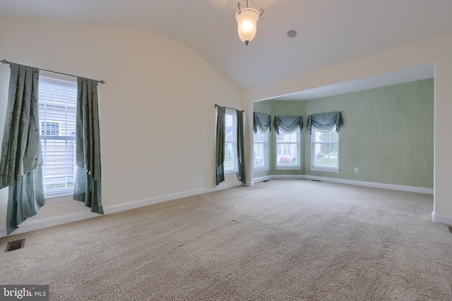 spare room featuring vaulted ceiling and carpet floors