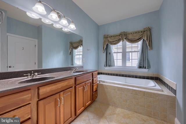 bathroom with vanity, tiled bath, and tile patterned flooring