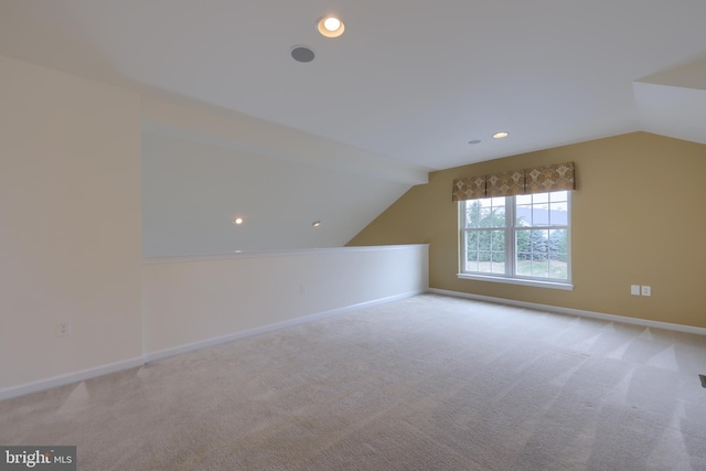 bonus room with light colored carpet and lofted ceiling