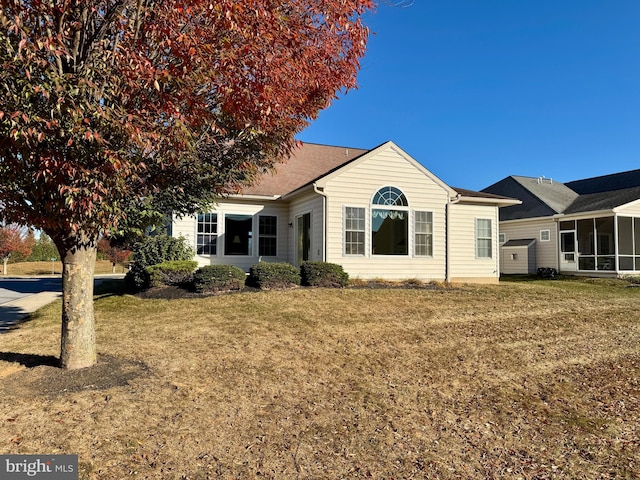 view of front of property with a sunroom and a front lawn