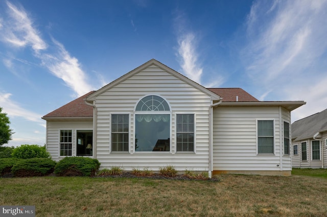 rear view of property featuring a lawn