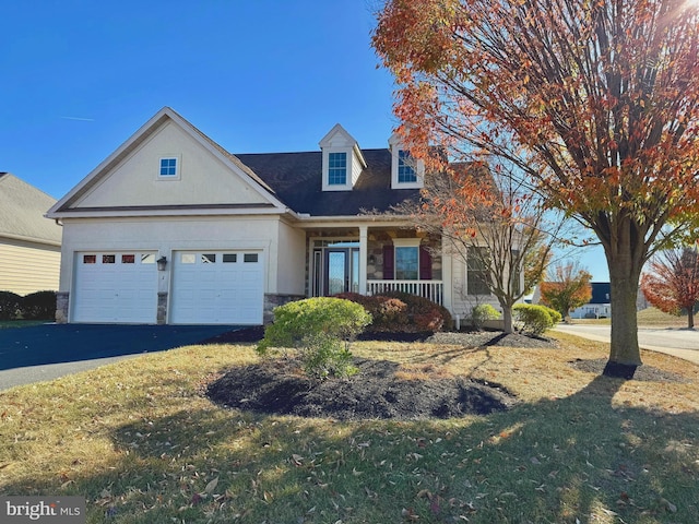 cape cod house featuring a front lawn, a garage, and covered porch