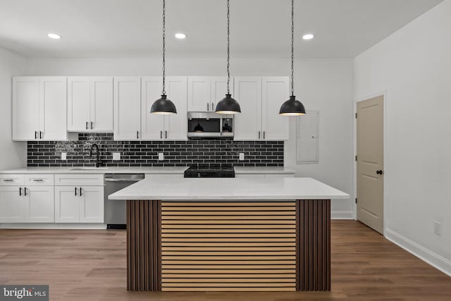 kitchen featuring stainless steel appliances, sink, hanging light fixtures, light hardwood / wood-style flooring, and white cabinets