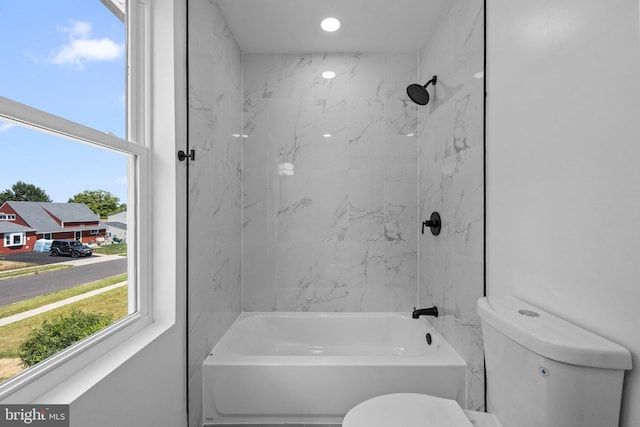 bathroom with tiled shower / bath and toilet