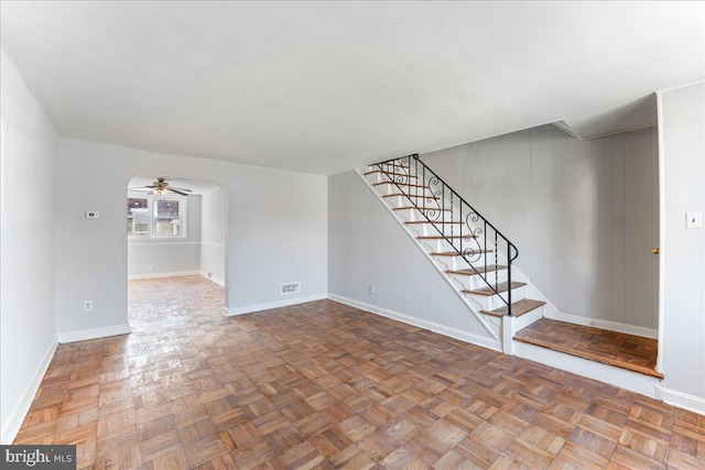 unfurnished living room featuring parquet flooring and ceiling fan