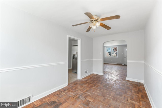 unfurnished room featuring ceiling fan and dark parquet floors