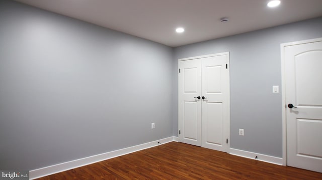 unfurnished bedroom with dark wood-type flooring