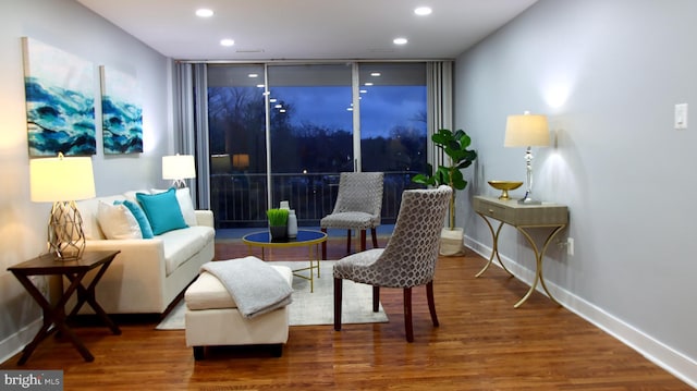 sitting room with hardwood / wood-style flooring and expansive windows