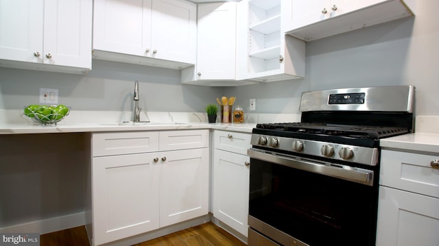 kitchen with gas range, light hardwood / wood-style floors, and white cabinetry