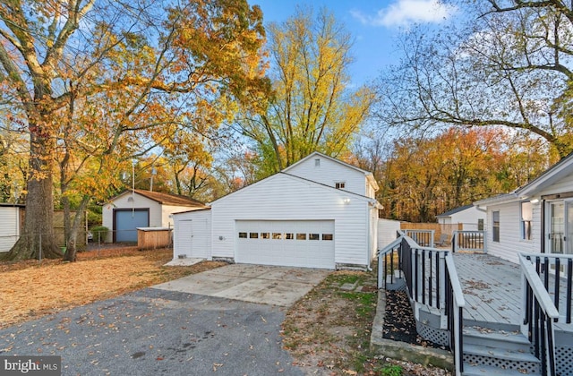 exterior space with an outbuilding, a garage, and a deck