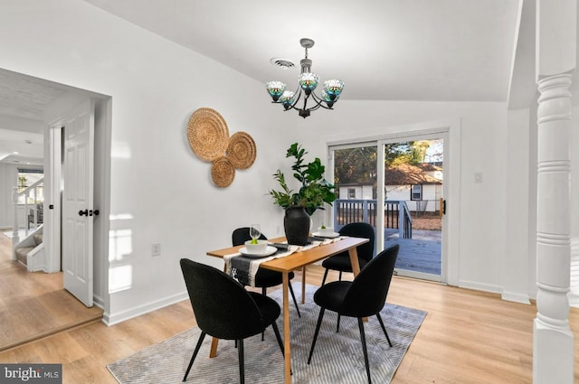 dining area with ornate columns, an inviting chandelier, a healthy amount of sunlight, and light hardwood / wood-style flooring